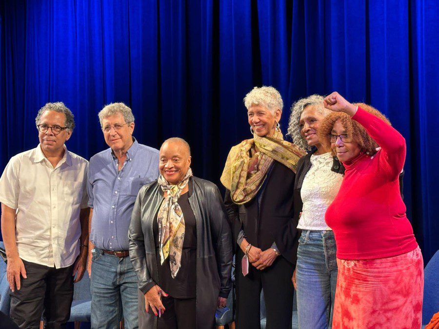 Six people stand on stage, from left: Jeffrey Henson Scales, Stephen Shames, Deborah Willis, Ericka Huggins, Cheryl Dawson and Regina Jennings.