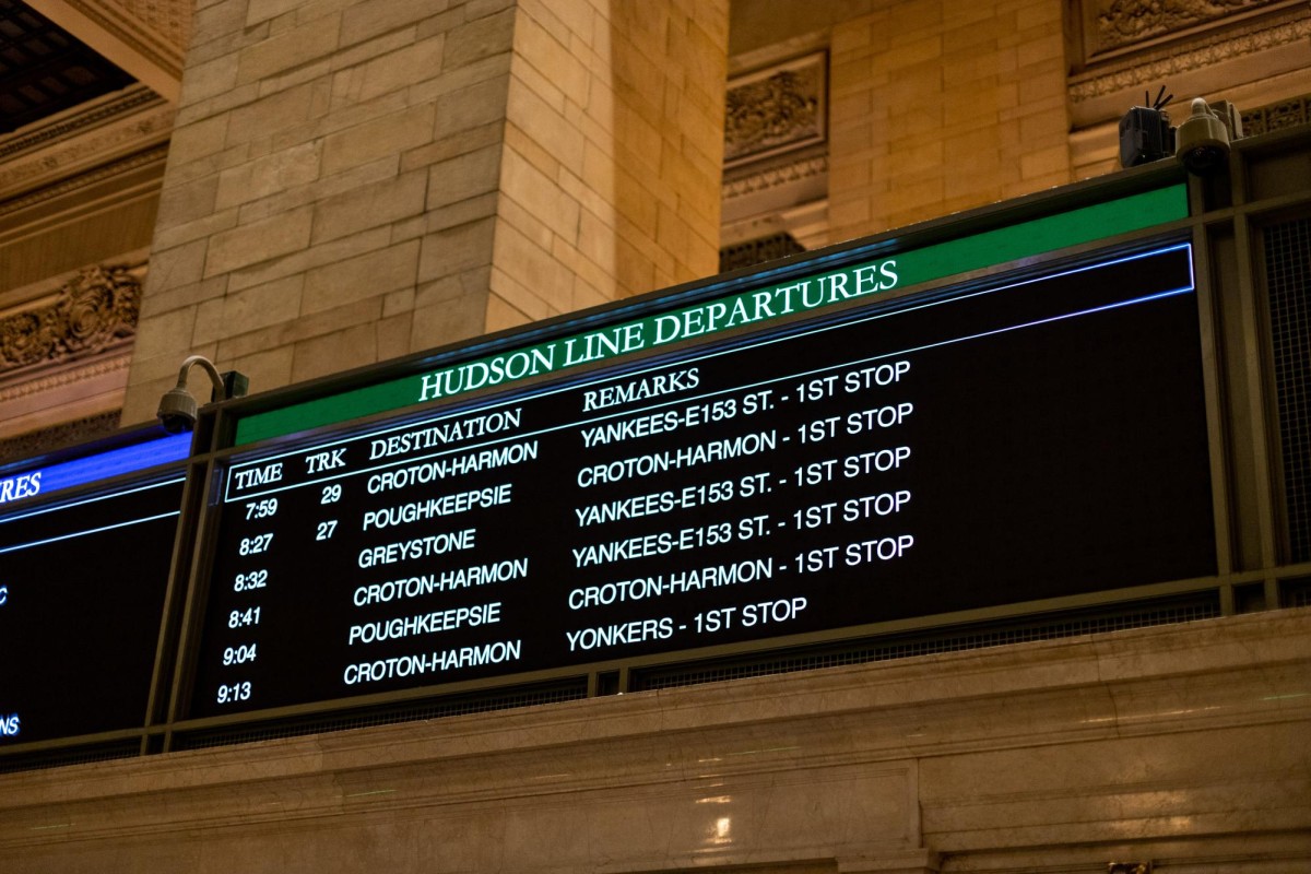 A sign inside Grand Central Terminal that says “Hudson Lines Departures”, with departure times, track numbers, and destinations listed on it.