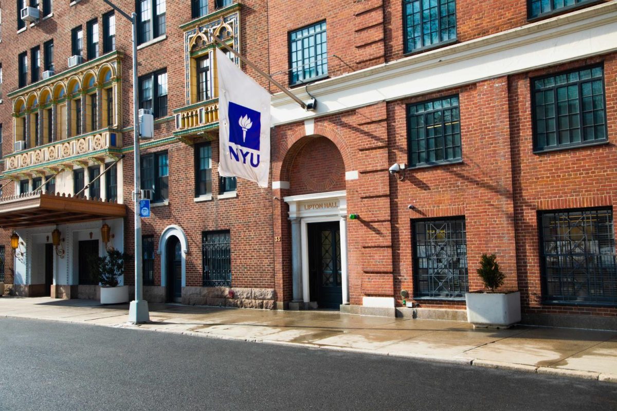 An N.Y.U. flag hanging on top of the entrance to Lipton Hall.